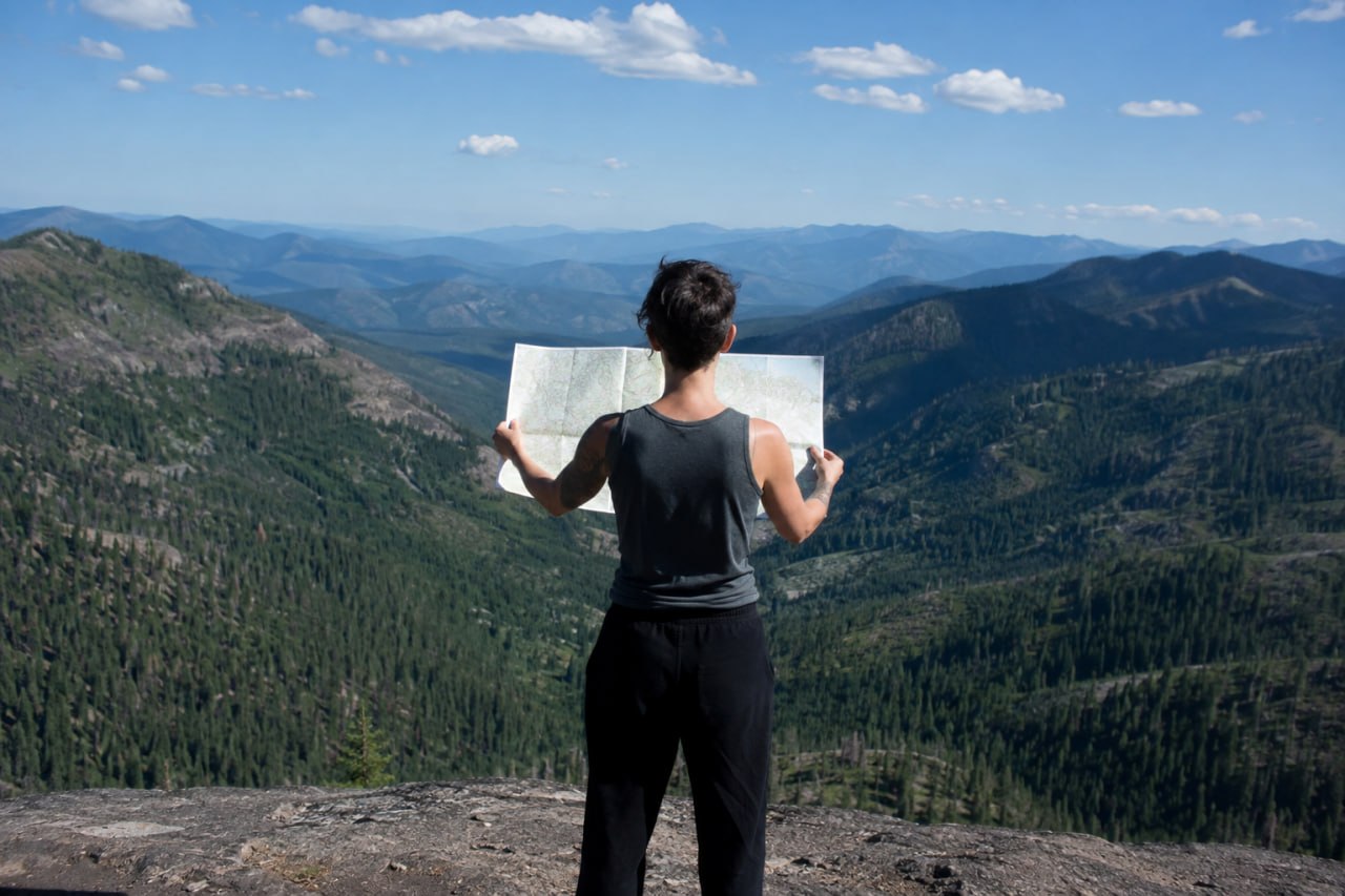 A hiker viewing a map from a mountain overlook
